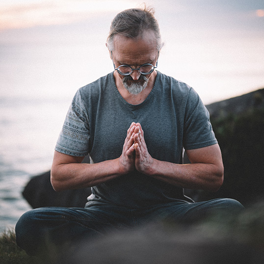 yoga teacher meditating on rock by the ocean in Tofino, BC