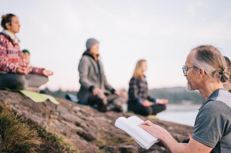 group studying yoga history and philosophy on a beach in Tofino
